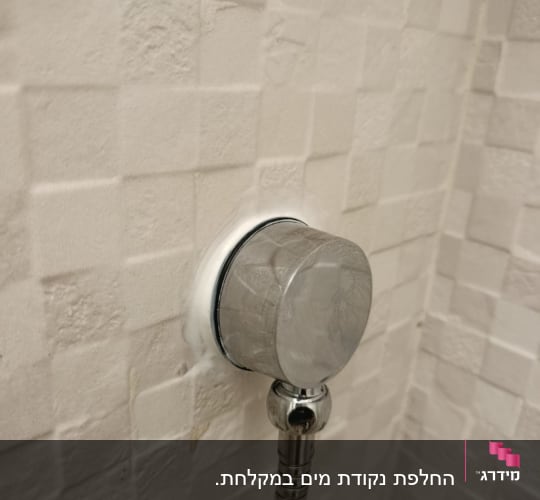חיבור צינור מתכת לקיר בחדר אמבטיה